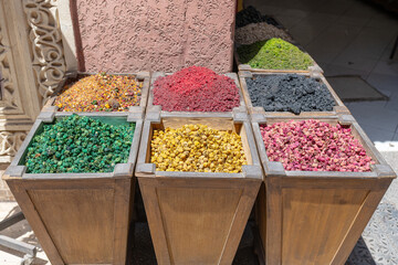 Vibrant spices and herbs are neatly arranged in wooden boxes, creating a captivating display in a...