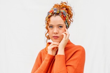 A woman with red hair and a colorful scarf on her head