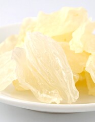 Pale yellow, translucent, dried fruit slices on a white plate