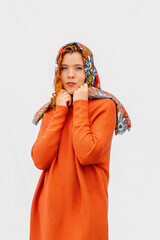 A woman wearing an orange dress and a scarf