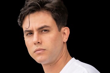 A man with short hair and a beard is looking at the camera