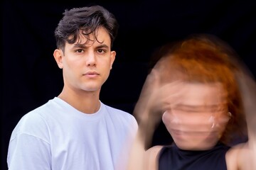A man and a woman are standing in front of a black background
