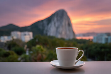 steaming cup of coffee sits invitingly on clean surface creating cozy atmosphere against breathtaking natural