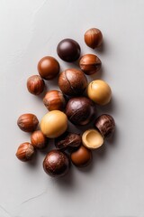 Obraz premium A delightful assortment of chocolate and hazelnut candies arranged beautifully on a neutral background, perfect for use in advertisements, packaging, or blogs related to sweets and confectionery,