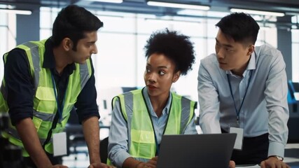 Diverse group of professionals engages in a collaborative project within a modern office setting. They focus on a laptop while discussing ideas and sharing insights in their workplace attire