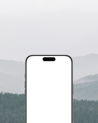 Smartphone mockup with blank white screen against misty mountain background