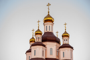 Beautiful orthodox church with golden domes and crosses shining against a clear sky, representing faith, tradition, and architectural splendor