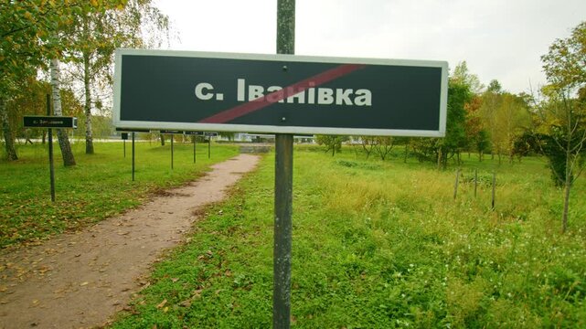 A sign marking the former village of Ivanivka  within the Chernobyl Exclusion Zone, Ukraine. The red line through the name signifies its abandonment after the 1986 nuclear disaster