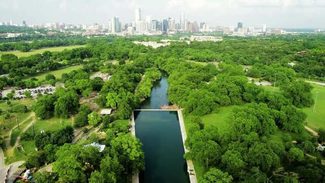 Aerial view of barton springs pool with austin texas skyline in the background