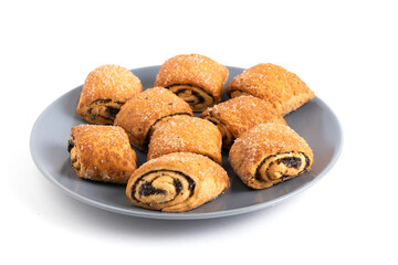 Cinnamon rolls with poppy seeds on a plate isolated on white background.