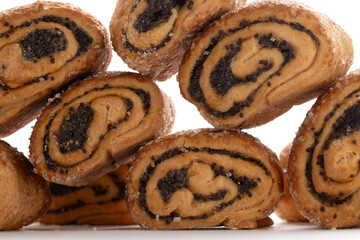 Cookie rolls with poppy seeds on white background.