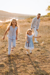  happy family having fun with two children in blue clothes on nature