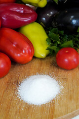 fresh vegetables and salt on a wooden table