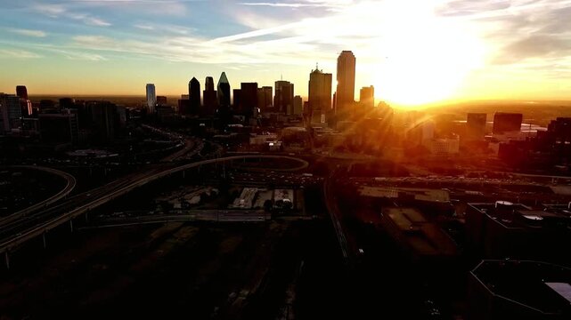 Aerial view of the dallas skyline at sunrise with the sun shining through the buildings