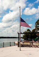 American flag at half staff next to the water