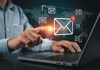 Businessman interacting with digital email icons and world map overlay on a laptop screen