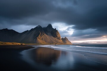 Dramatic icelandic landscape with black sand beach and majestic mountains at sunset