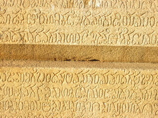 Ancient stone surface with carved inscriptions and patterns  