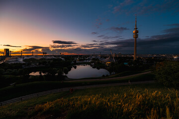 Sonnenuntergang über dem Olympiapark München mit Olympiaturm und Zeltdach