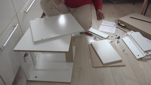 Preparing to assemble a piece of furniture, front view