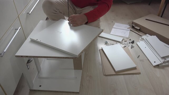 Preparing to assemble a piece of furniture, front view