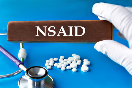 Cubes with the word NSAID in the hand of a doctor.