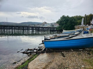 Obraz premium Small boats on a cloudy shore in Bulgaria in Balchik on the embankment