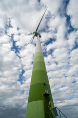 Windkraftanlage aus der Froschperspektive vor dynamischem Wolkenhimmel – Symbol für erneuerbare Energien