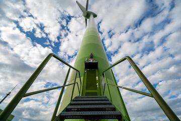Windkraftanlage aus der Froschperspektive vor dynamischem Wolkenhimmel – Symbol für erneuerbare Energien