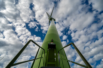 Windkraftanlage aus der Froschperspektive vor dynamischem Wolkenhimmel – Symbol für erneuerbare Energien