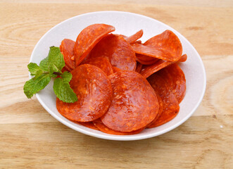 Slices of pepperoni on white background 