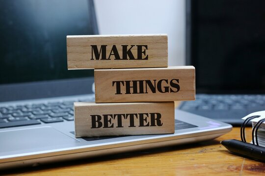 wooden blocks spelling out 'Make Things Better,' placed on a laptop keyboard. Represents progress, motivation, business improvement, leadership, digital innovation, and positive actions