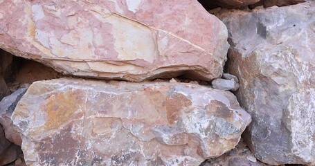 Closeup camera movement across dry stack wall showing numerous variation of colorful rocks of all textures and surfaces 4k