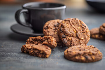 Sweet chocolate cookies and coffee cup on kitchen table.