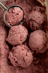 Creamy raspberry ice cream scoops in close-up, rich texture and vibrant pink color