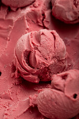 Close-up of pink berry sorbet scoops with frosty texture in natural light