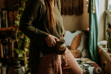 Hygge moment holding warm earthy mug with Autumn vibes