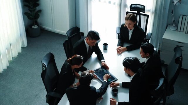 Top view of professional project manager present financial graph while holding tablet. Diverse group working together to analyze stock market investment data graph ay business conference. Directorate. - Powered by Adobe