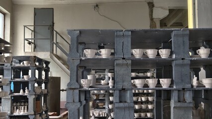porcelain products on the shelves at the factory, prepared for firing in the kiln. Tableware Making