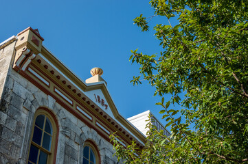 Ornate pedimented metal cornice on roofline showing 1884 on historic building in Georgetown Town Square in Texas © steheap