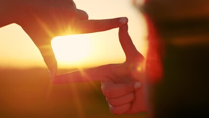 Seeing world differently. Business planning. Girl shows with her fingers frame symbol, sun. Hands of young woman director of photography make gesture in frame, sunset park. Everything is like in movie