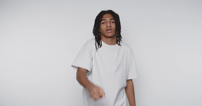 footage of young individual expresses surprise and assertiveness while pointing towards something on white background