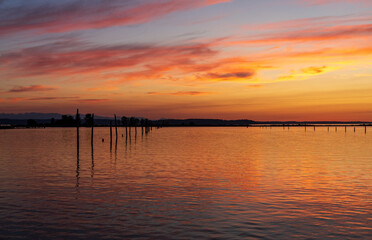Old wooden posts as leading line to sunset off Everett in Possession Sound Washington State