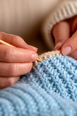 Vertical close up of knitting lace pattern in soft blue yarn, handmade textile with cozy grandmacore aesthetic