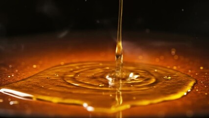 A cascade of golden liquid spills into a heated puddle creating ripples and releasing wisps of steam - Powered by Adobe