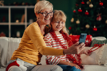 Grandmother and granddaughter making a video call on christmas day