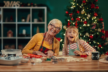 Grandmother and granddaughter making christmas cookies together