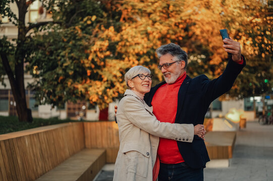 Senior couple taking selfie in autumn park