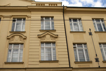 A prominent and large yellow building that features a considerable number of windows, enhancing its facade and design appeal in an urban environment
