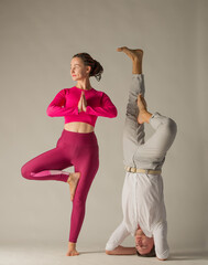 couple man and woman in yoga pose.man upside down and woman in yoga pose on white background online...